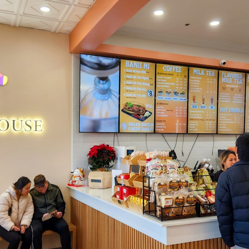 BB Tee House counter displays banh mi, coffee, milk tea, fruit tea, snacks, and a menu while customers order.